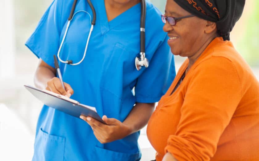 beautiful young african nurse explaining medical test result to senior patient
